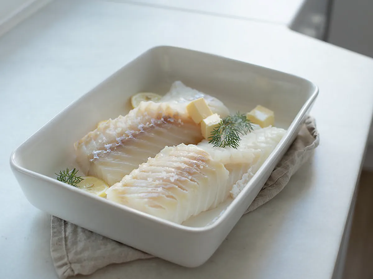 Lettsaltet torsk i ildfast form med smør, sitron og dill, klar for ovnen